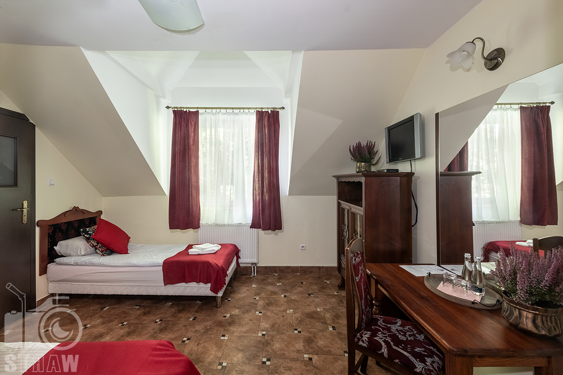 Sesje fotograficzne wnętrz dla hoteli, tu zdjęcie pokoju z dwoma łóżkami i biurkiem w dworku Pałacu Tarnowskich w Ostrowcu Świętokrzyskim.