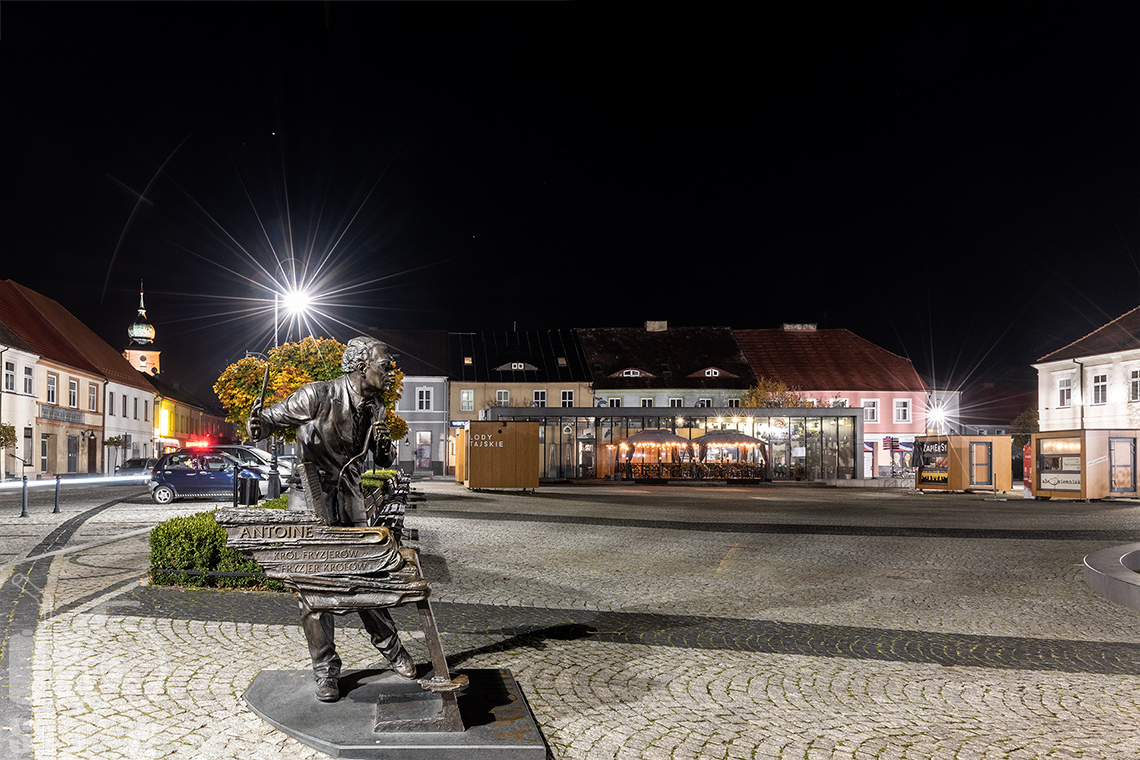 Fotografia architektury i zdjęcia miejskie, na zdjęciu nocny kadr i ujęcie sieradzkiego ryku oraz pomnika Antoinea, króla fryzjerów.