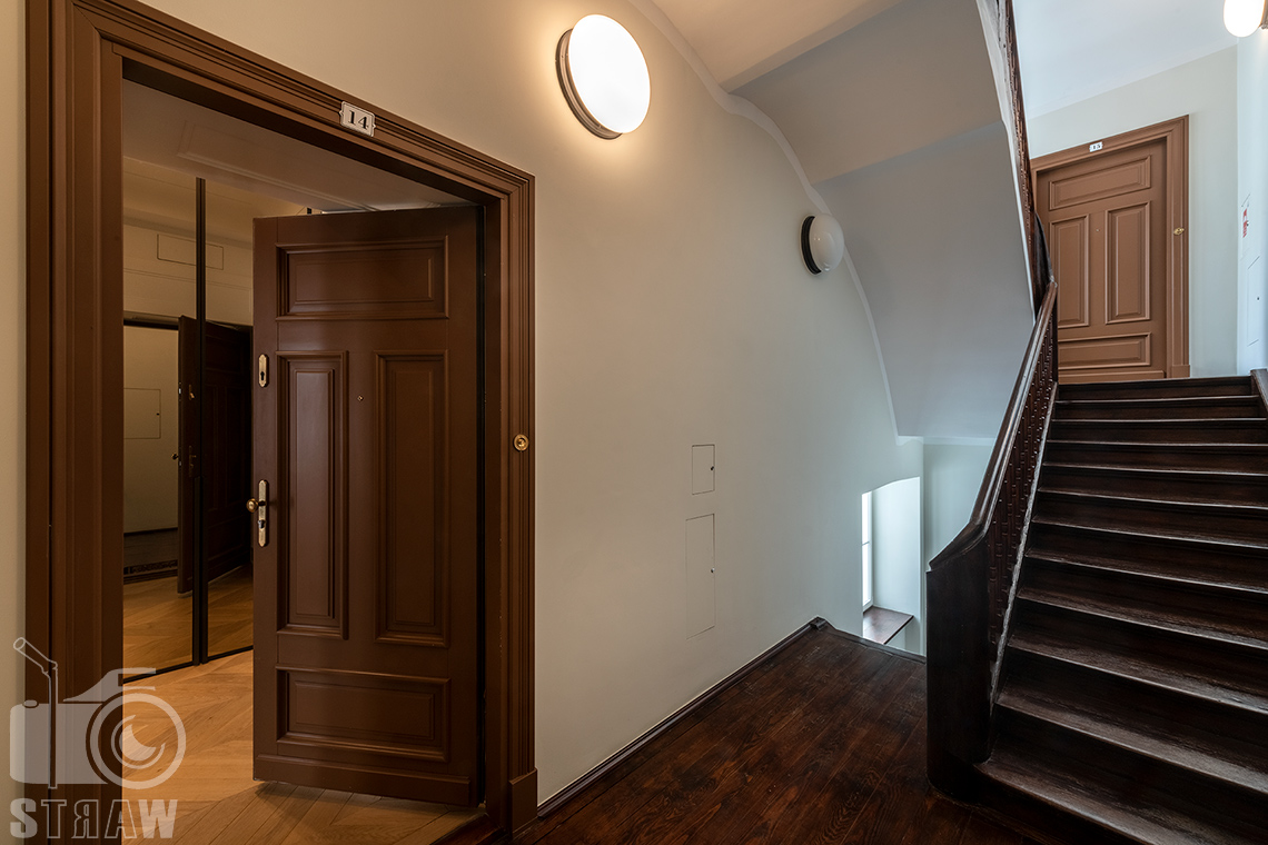 Fotografia wnętrz na wynajem krótkoterminowy, zdjęcie klatki schodowej w kamienicy i wejście do apartamentu.